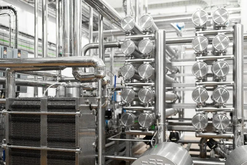 Planta industrial de refrigeracao com tubulacoes de aco inox, trocador de placas e chillers